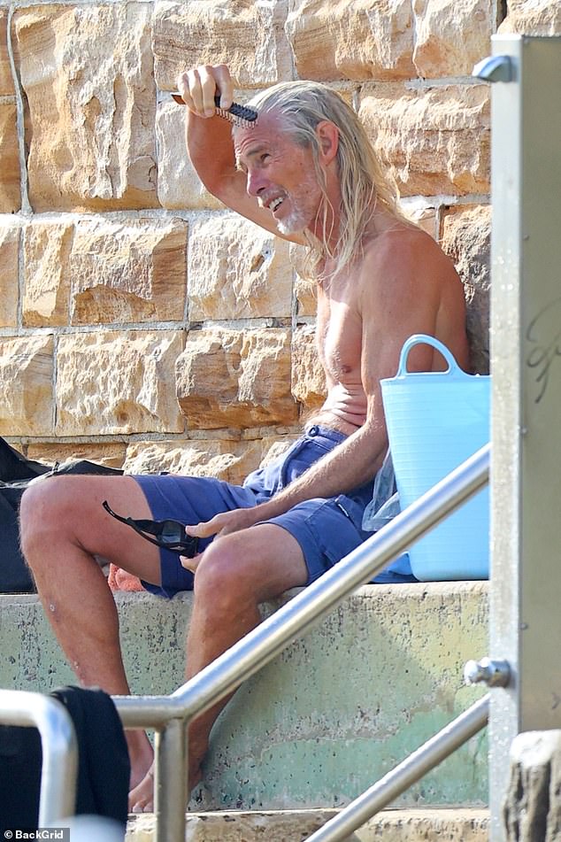 The reclusive comedian was seen brushing his long silver locks after a morning swim.