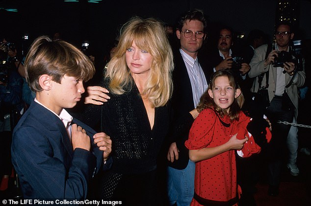 Throughout the years of being mostly separated from her biological father, Kate and her brother Oliver have praised Kurt Russell for being the constant father in their lives;  They are seen with Russell and his mother Goldie Hawn in December 1988.