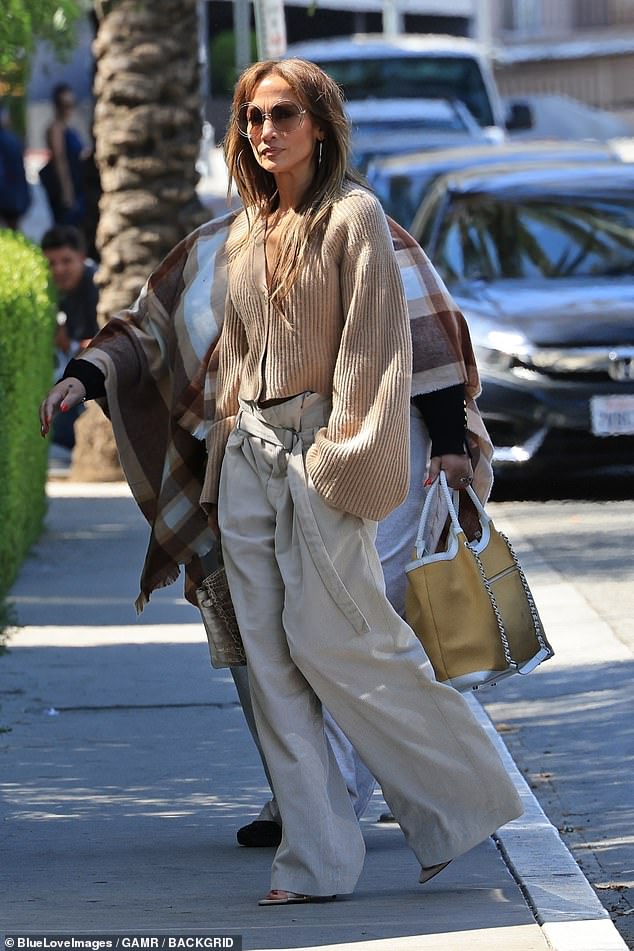 The 54-year-old pop star continued her baggy pants parade with wide-leg, belted khaki pants that she paired with open-toed heels and a cropped brown ribbed cardigan with bell sleeves.