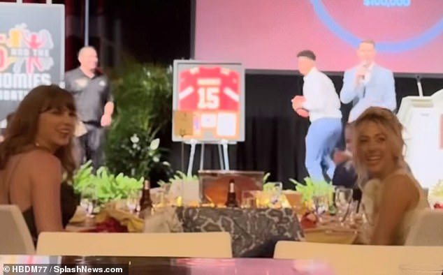Swift shared a table with Patrick's wife, Brittany Mahomes (right), and the ladies seemed amused as the 28-year-old Kansas City Chiefs (right) lobbed a football over the heads of the black-clad crowd.