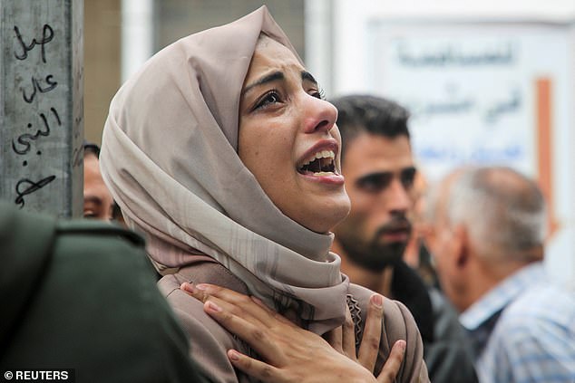 A mourner reacts during the funeral of Palestinians killed in Israeli attacks