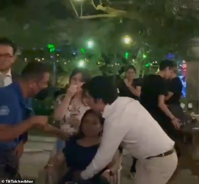A paramedic questions a guest at a wedding in Mexico on Saturday after at least 100 guests fell ill from eating dessert served by a caterer.
