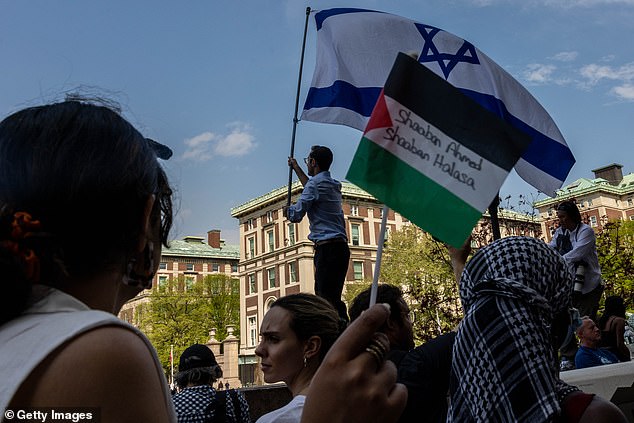 A protester waves the Israeli flag at the camp set up in support of Palestinians in Gaza.