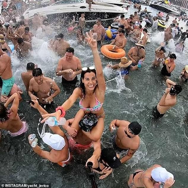 A bikini-clad woman was seen perched on a man's shoulders as she posed for the camera as a water bottle slipped from her hand.