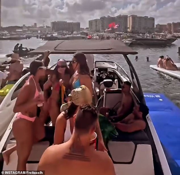 A group of bikini-clad men and women are seen crowded onto a boat during Boca Bash.