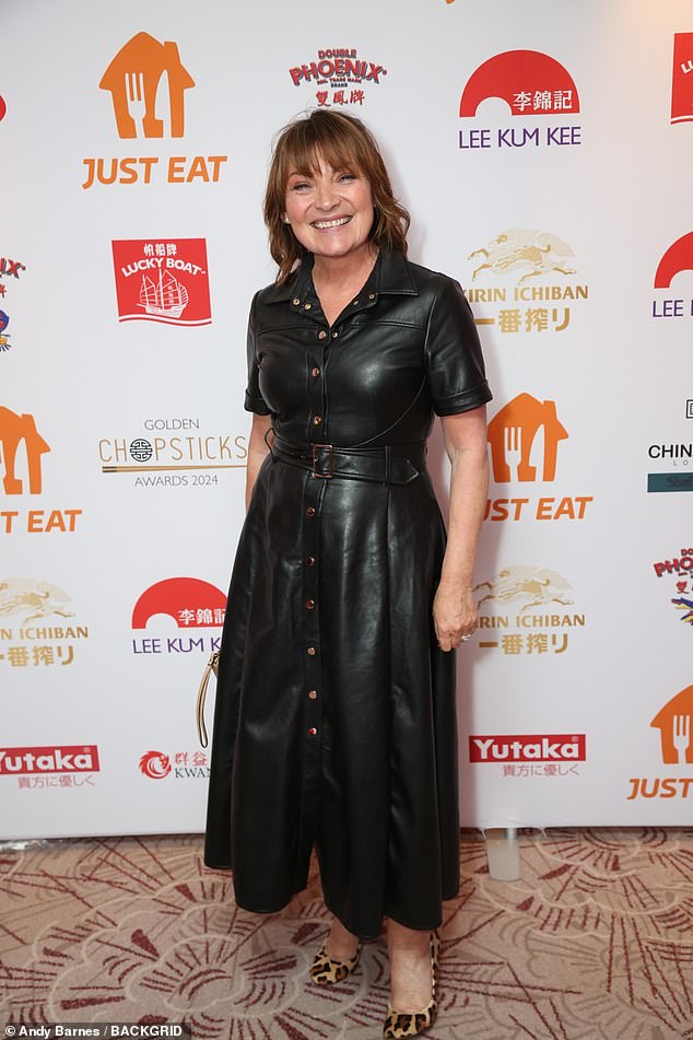 The TV legend, 64, oozes style in a long black leather dress with short sleeves and a belt, making a statement with animal print stilettos.
