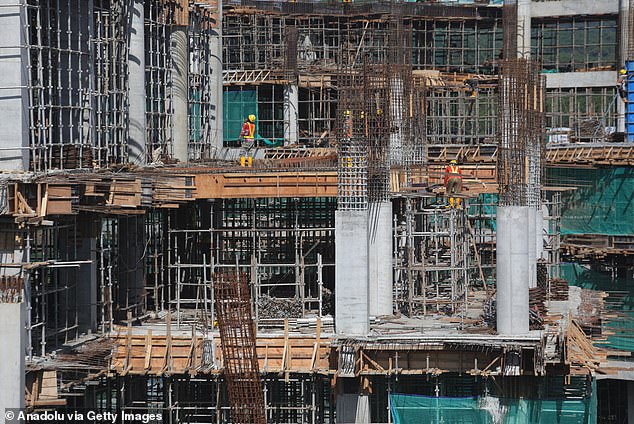 Workers complete the construction of a multi-story building in Nusantara