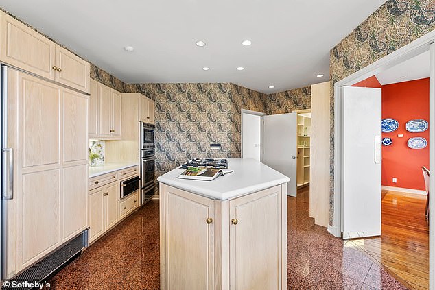 Wood-paneled doors create a stylish island kitchen with countertop stove