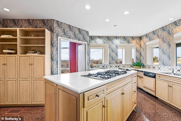 Granite floors run throughout the kitchen with eye-catching wallpaper.