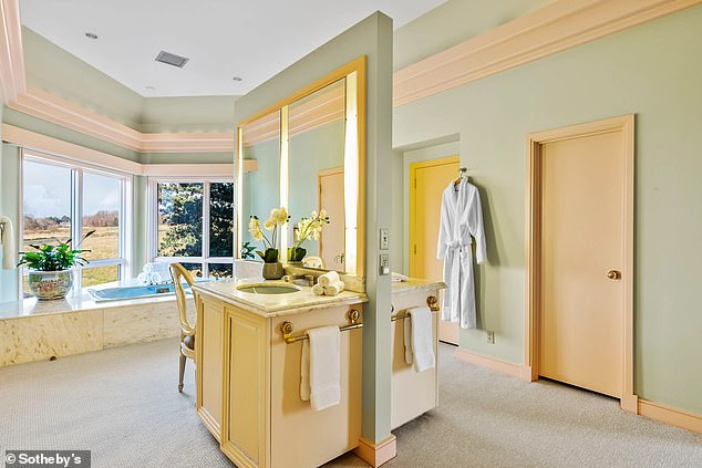 Double sinks are located on either side of this walk-in closet and mirrored bathroom with dressing areas.