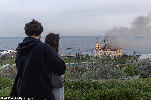 A couple looks at a burning building damaged as a result of a missile attack in Odessa on April 29.