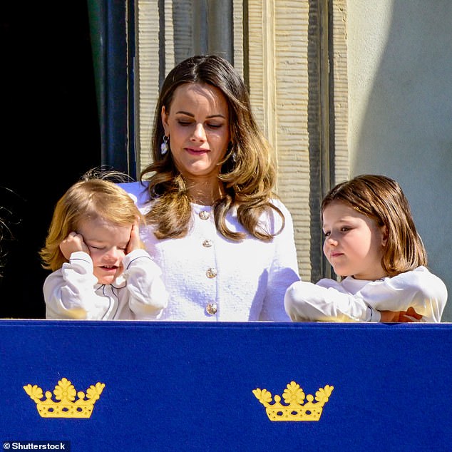 Princess Sofia's youngest son, Prince Julian, rubs his eyes on the Palace balcony today.