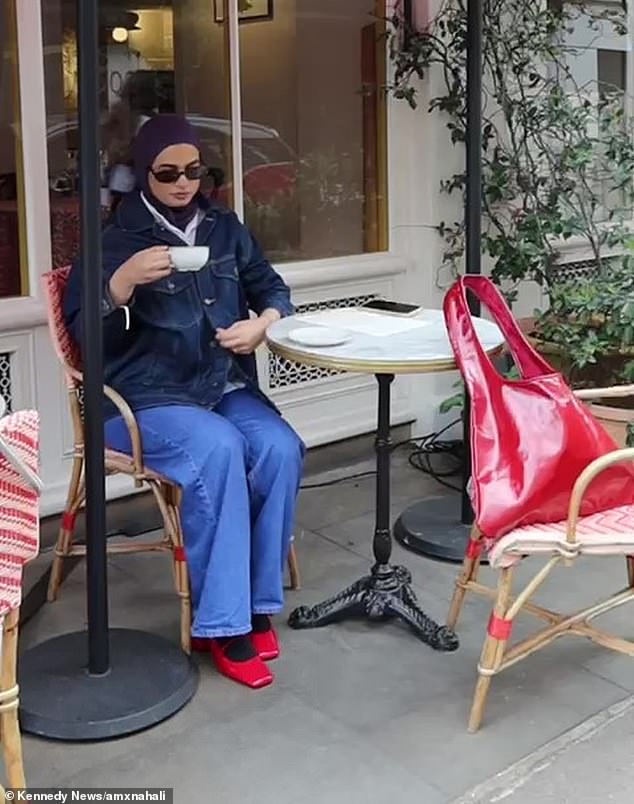 Aminah can be seen sitting with her phone on the table, before the woman approaches.