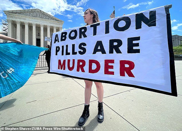 He also did not raise the possibility that states could implement programs to monitor women's pregnancies and prosecute them if they violate abortion bans.  Pictured: A pro-life protester in front of the Supreme Court on April 15 advocates for a ban on a pill that terminates pregnancy.