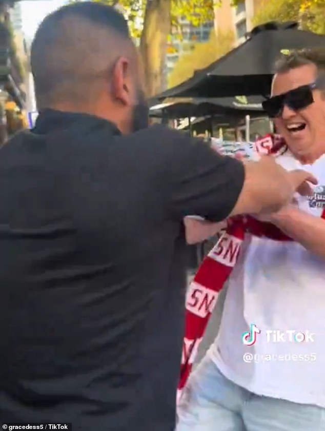 The AFL supporter wearing a Sydney Swans scarf around his neck (pictured) was seen confronting a bearded protester.