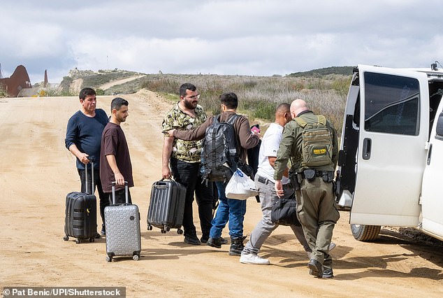 Migrants with carry-on luggage are apprehended at the El Campo border on March 13