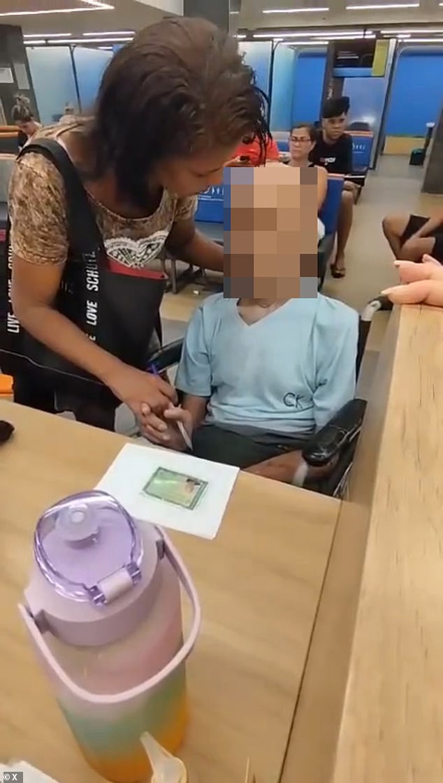 The bank employees began filming the couple and ended up calling an ambulance and the police as she used her hand to hold the deceased pensioner's head up and said: 'Man, are you listening?  You have to sign it.  I can't sign for you'