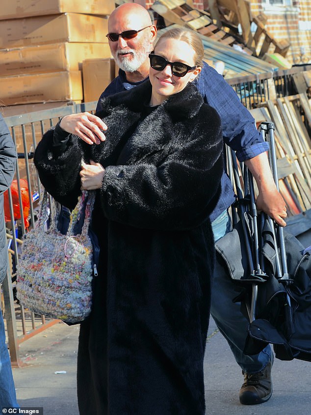 Amanda Seyfried looked comfortable in a voluminous fur coat while working on the set of the upcoming series Long Bright River in New York on Friday.