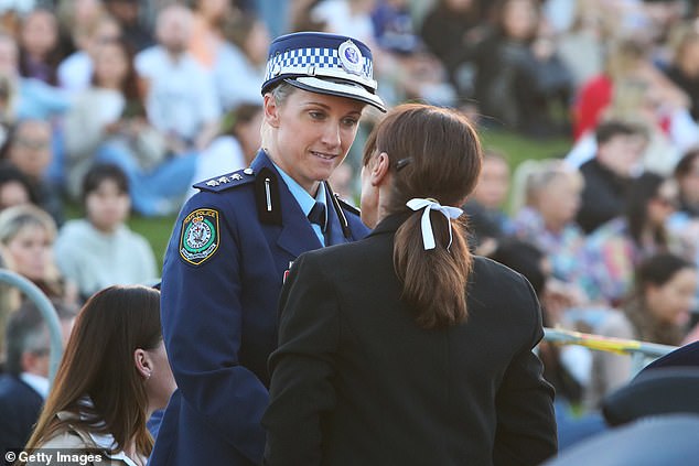 Inspector Amy Scott (left) joined tearful mourners at a somber candlelight vigil to remember those murdered at Westfield Bondi Junction last Saturday.