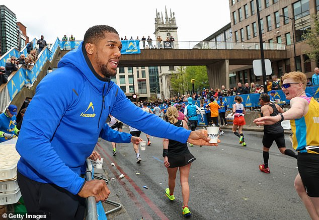 Anthony Joshua was seen handing out Lucozade and cheering on the London Marathon runners on Sunday.