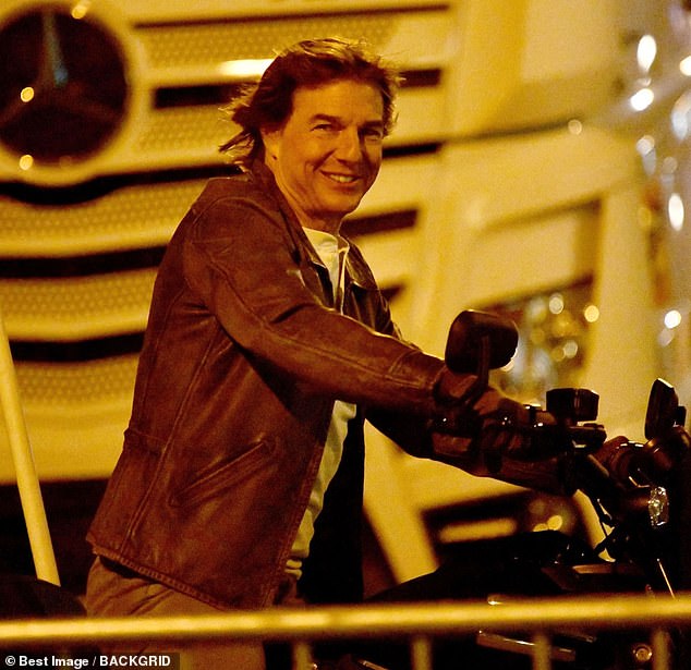 Tom Cruise looked in high spirits as he hopped on a motorcycle to speed through the streets of Paris while filming intense scenes on Thursday.