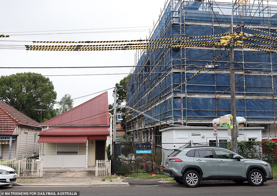 An elderly man has taken a defiant stance against a property developer building a six-storey apartment complex where the other half of his duplex used to be.