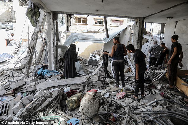 Palestinian residents in Gaza examine the consequences of an Israeli attack