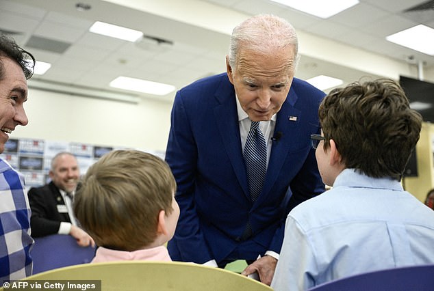 US President Joe Biden speaks with two children as he meets with campaign volunteers and supporters.
