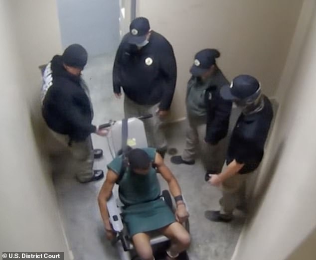 Footage from a small room at the Appling County Jail shows Harris pinned to a chair by his wrists, ankles and torso as the four defendants surround him.