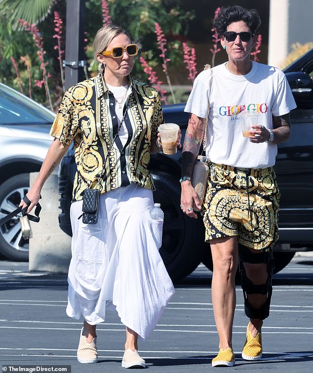 While on vacation in Palm Springs, Braunwyn Windham-Burke and her fiancée Jennifer Spinner stepped out for coffee, each wearing a half set of black and gold printed shorts.