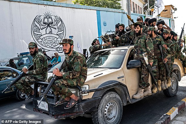 Armed Taliban security personnel ride in a convoy of vehicles as they parade near the US embassy in Kabul on August 15, 2023, during celebrations marking the second anniversary of their takeover.