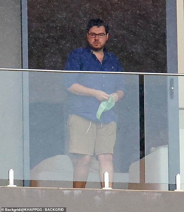 Bruce Lehrmann is pictured picking up dog poop on the balcony of his former home in Sydney in December last year.