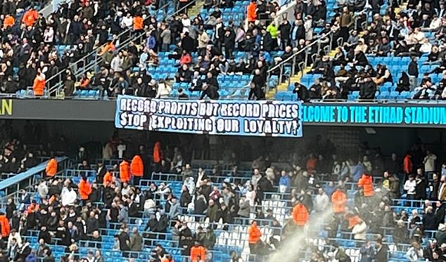 Manchester City fans raise a banner in frustration over the increase in ticket prices for next season.