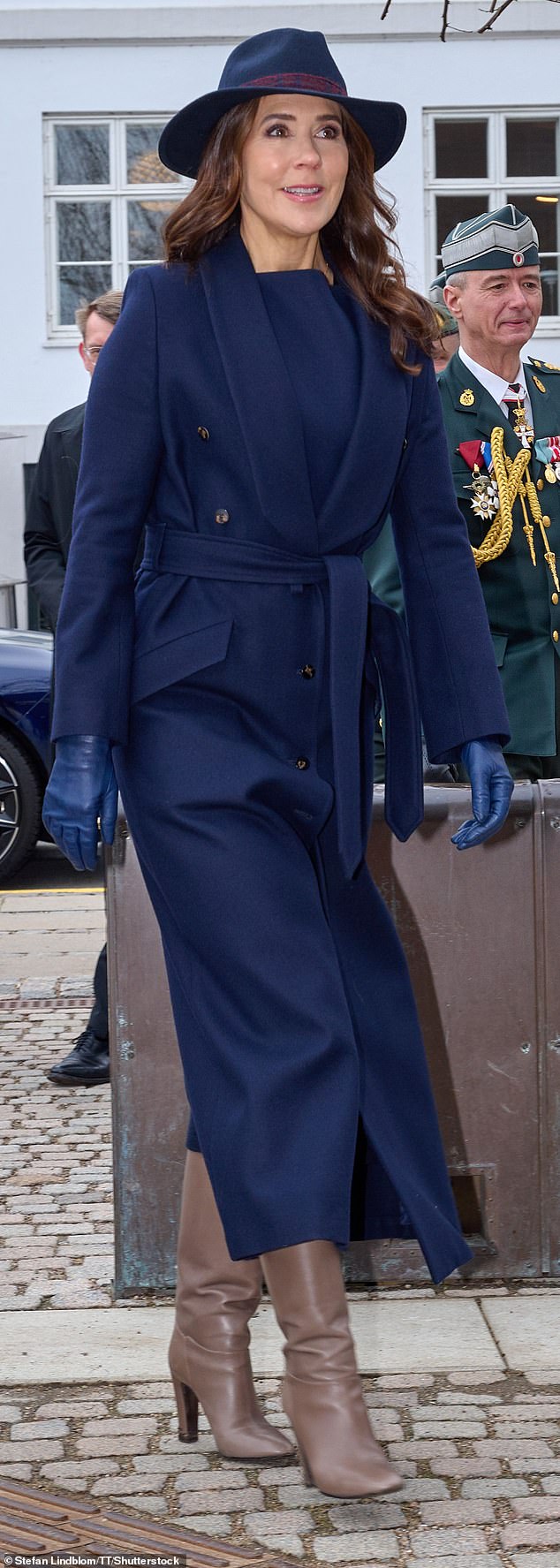Queen Mary, 52, donned a long, elegant trench coat which she tied at the waist to show off her slender and sophisticated figure.