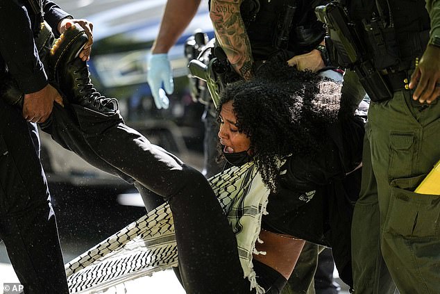 A female protester is seen being carried away by several officers while she screamed and chanted.