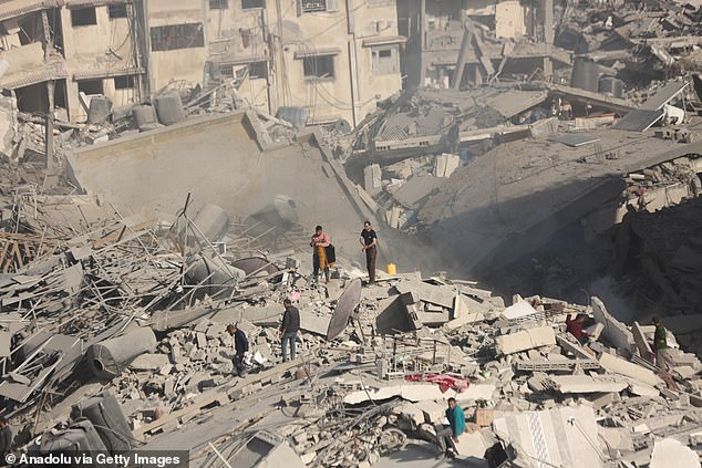 Palestinians are seen gathering around the burned and destroyed Al-Shifa hospital in Deir Al-Balah, Gaza, April 1, 2024. Many buildings, including the hospital, have been severely damaged by the airstrikes.