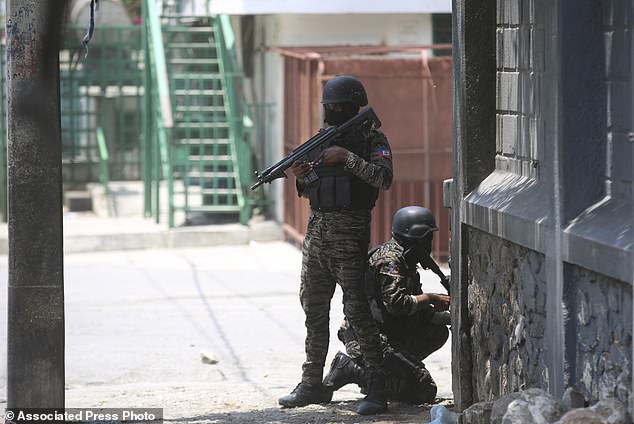 Police take cover during an anti-gang operation next to the National Palace in Port-au-Prince, Haiti, Monday, April 8, 2024.