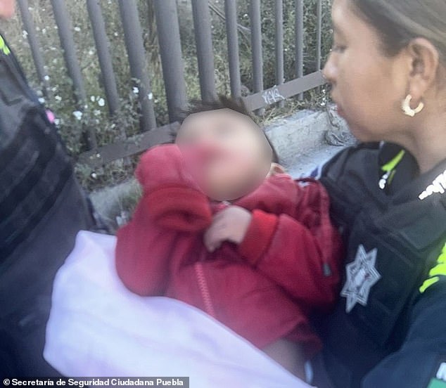 Puebla police officer Betsabé Zallas holds a two-year-old boy who was found abandoned in a suitcase abandoned on a sidewalk on Tuesday.  The child had bruises on his face and was treated for hypothermia and malnutrition.  The authorities are looking for these parents.