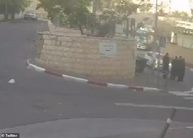 In the images you can see a white car speeding down a road in Jerusalem while three Jews stand on the side of the road and talk.