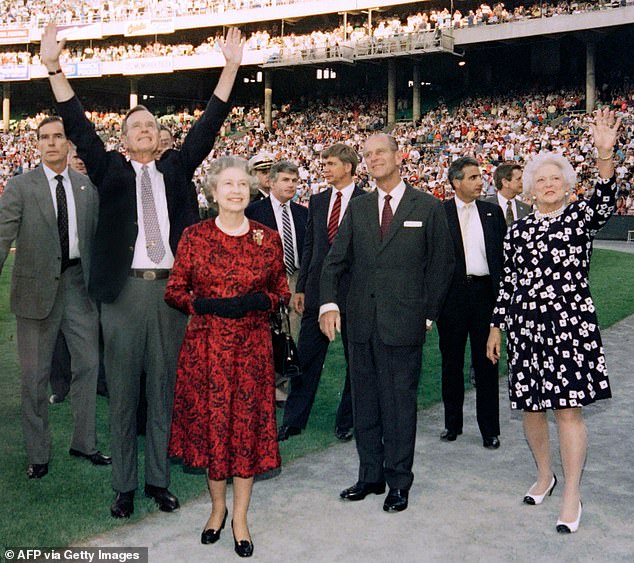 President George HW Bush (second from right) extends his arms to the crowd at a Baltimore Orioles game where he brought Queen Elizabeth (center right) and Prince Philip (center left) during a state visit together to first lady Barbara Bush (right) in May.  15, 1991
