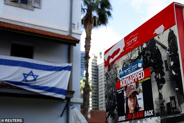 October 7, 2023 is a day that will forever be etched in the collective memory of the Jewish people.  Pictured: An Israeli flag hanging on a building near a poster of a woman kidnapped in the October 7 attack.