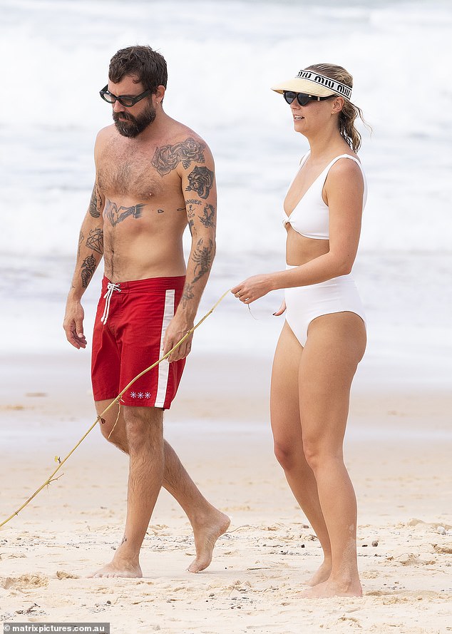 On Friday, the newly single blonde, 32, was all smiles as she hit the beach in Noosa, Queensland, with her new friend, fashion designer Matty Bouris (left).