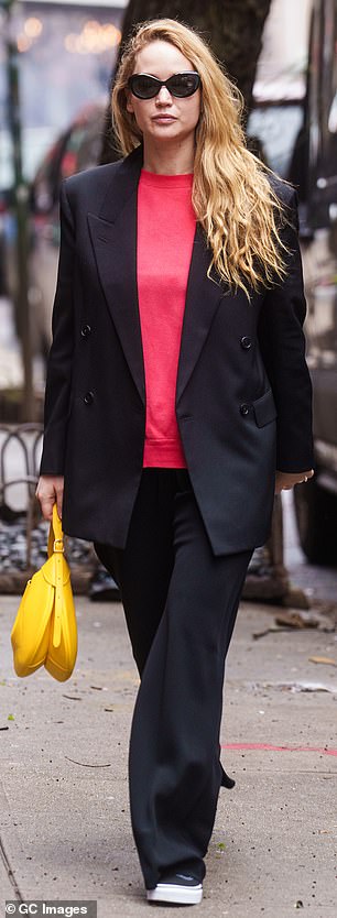 The 33-year-old actress stood out in a bright red crewneck sweater under a jet black double-breasted jacket as she walked along city sidewalks.