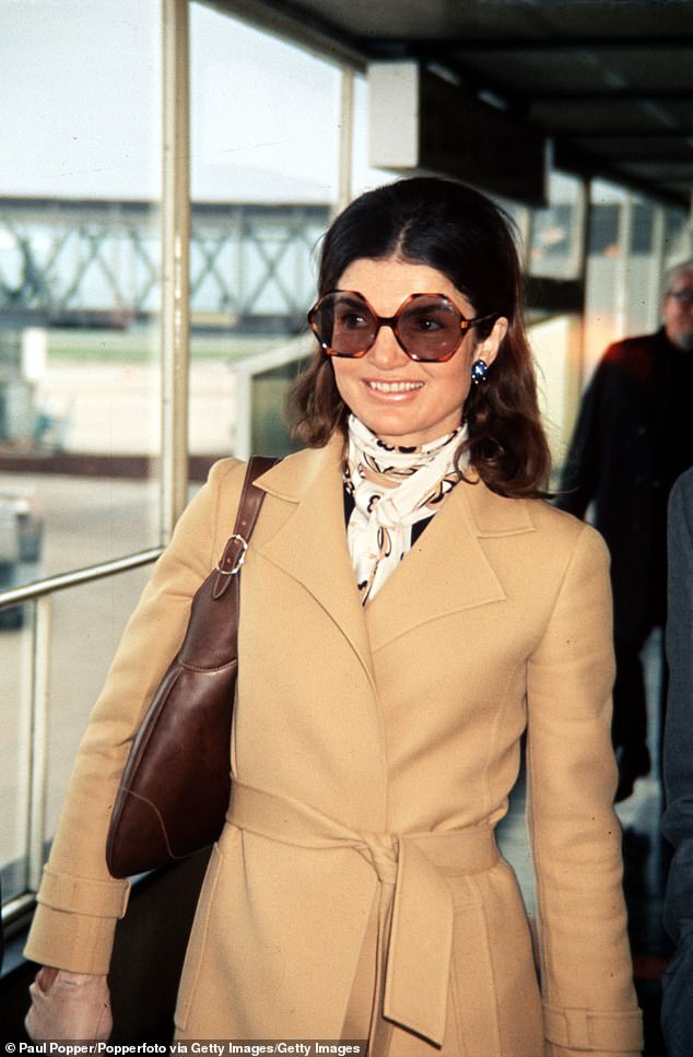 Onassis photographed in 1971 wearing her signature large sunglasses.