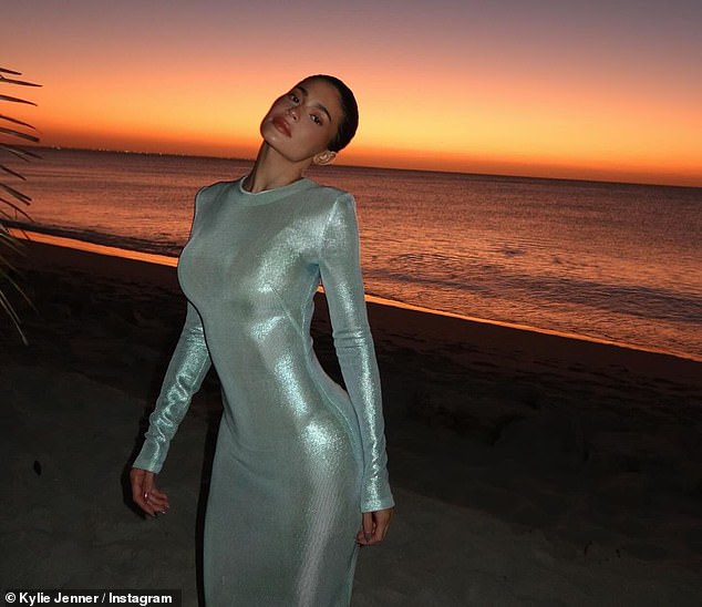Kylie posed on the beach at sunset with the metallic dress with the ocean in the background
