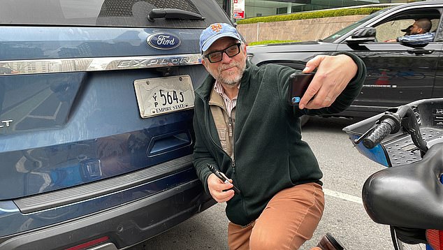 Gersh Kuntzman films himself exposing a battered license plate in New York City