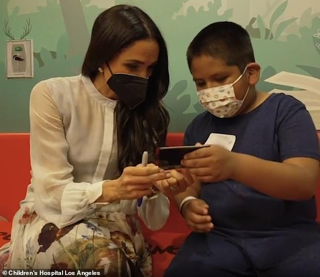 The Duchess of Sussex, 42, smiled warmly as she chatted with young patients and explained how the retro camera printing process works when she appeared on March 21.
