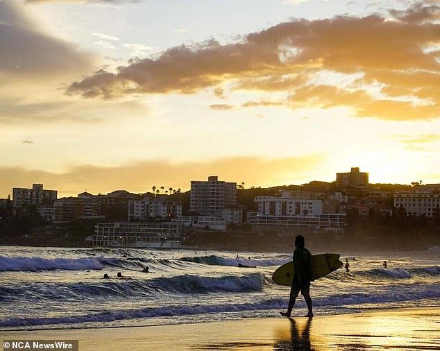 Australians in New South Wales, Victoria, ACT, South Australia and Tasmania will sleep an extra hour before morning (pictured in Bondi at sunrise).