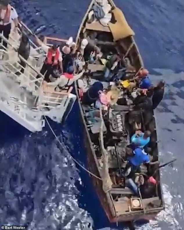 Footage captured the moment more than two dozen Cuban migrants were saved from a makeshift wooden boat about 20 miles off the coast of Cuba on Sunday.