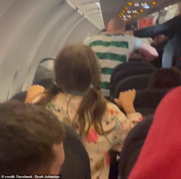 This is the moment a 'drunk' Celtic fan punches police officers in a shocking fight on an EasyJet flight 'after drinking a bottle of vodka'